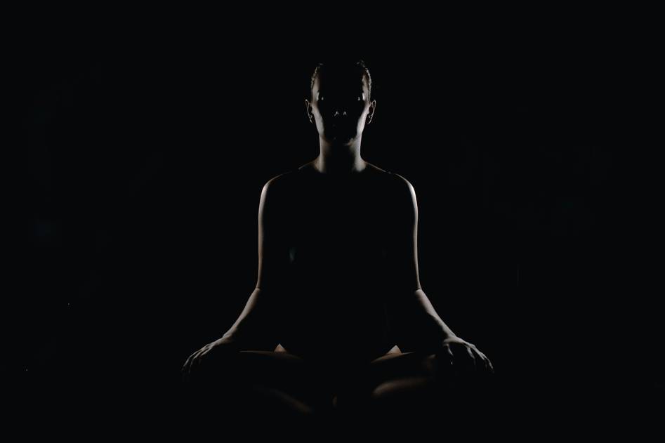 Peaceful person meditating on a soft mat in a sunlit room